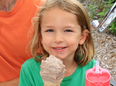 Happy kid holding an ice cream cone.